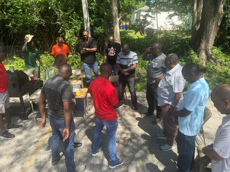 Men gathered together in prayer and fellowship at church
